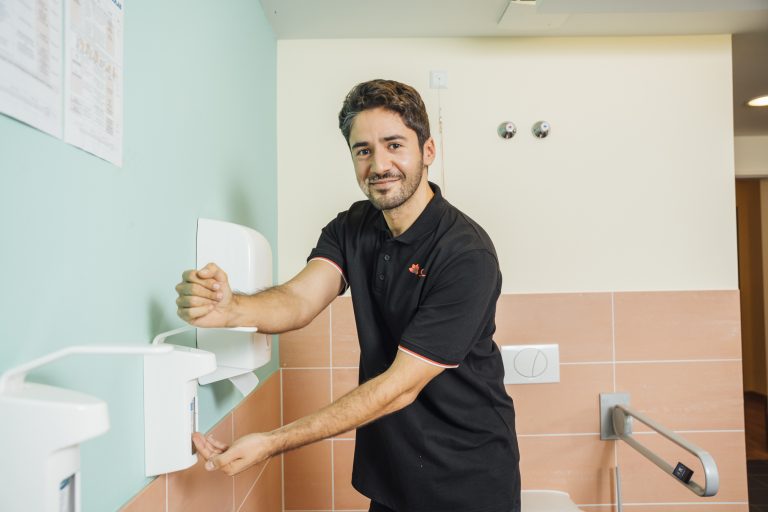 Mann desinfiziert seine Hände